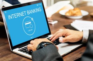 Pessoa acessando contas digitais em um notebook por meio de plataforma de internet banking, destacando a praticidade e segurança dos serviços financeiros online.