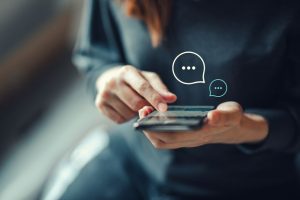Pessoa utilizando o celular para se comunicar em aplicativos de mensagens, representando a praticidade e inovação no acesso a empréstimos com garantia digital.